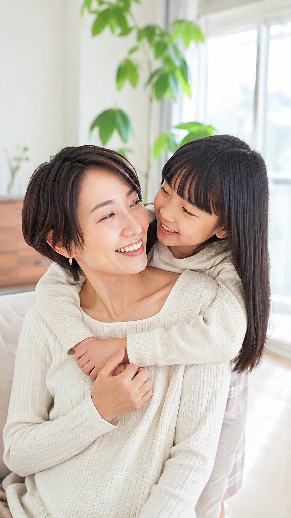 明るい自宅で笑顔を交わす母親と娘